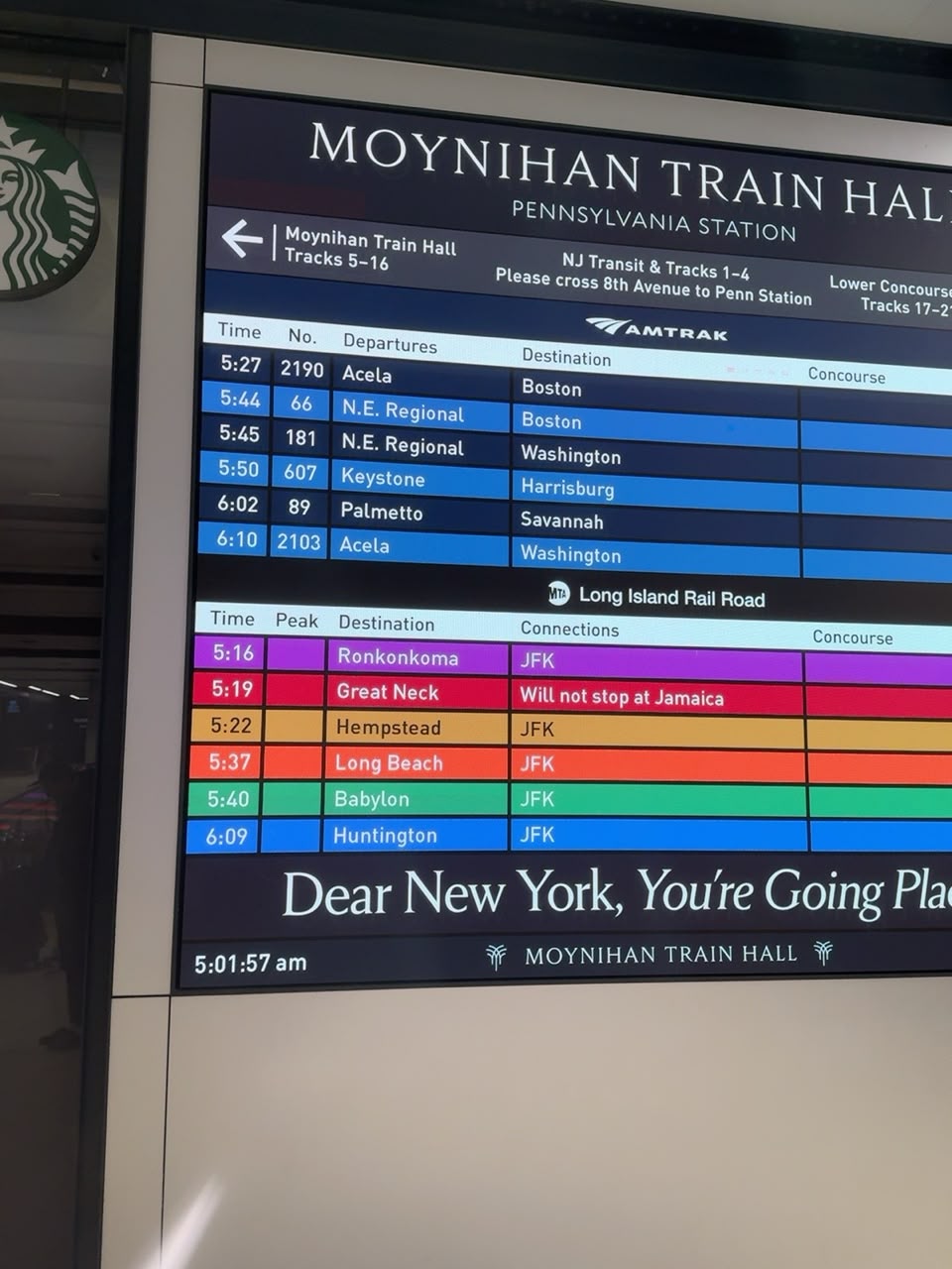Departure board inside Moynihan Train Hall showing early morning Amtrak and Long Island Rail Road services